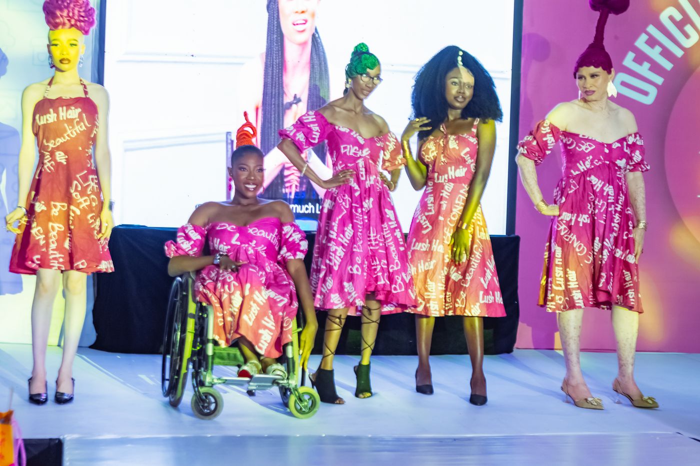 Models in Lush Hair branded gowns, including a model in a wheelchair, on the runway